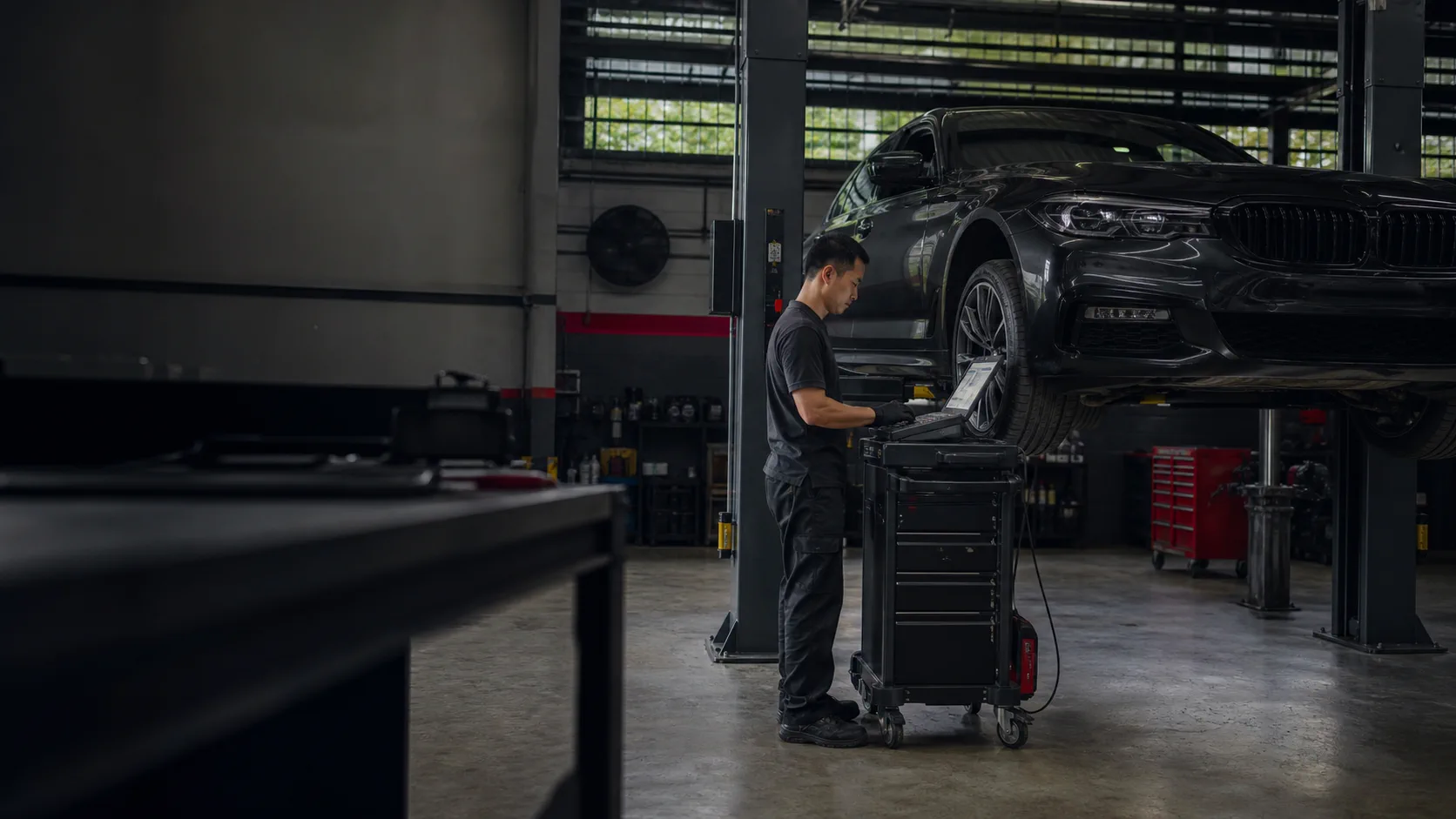 Technician checking a European sedan on a workshop lift